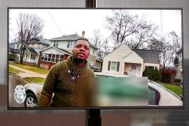 A TV display shows video evidence of a Grand Rapids police officer struggling with and shooting Patrick Lyoya.