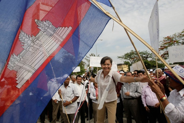 Mu Sochua holds a Cambodian flag as she takes part in a rally following the 2013 elections
