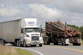 A truck is seen carrying logs in the United States