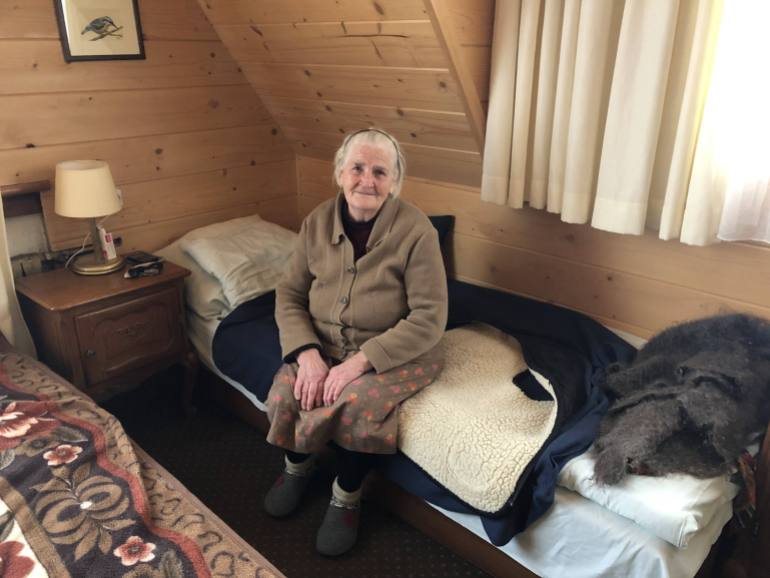 A photo of Anna Poluchek sitting on a bed.