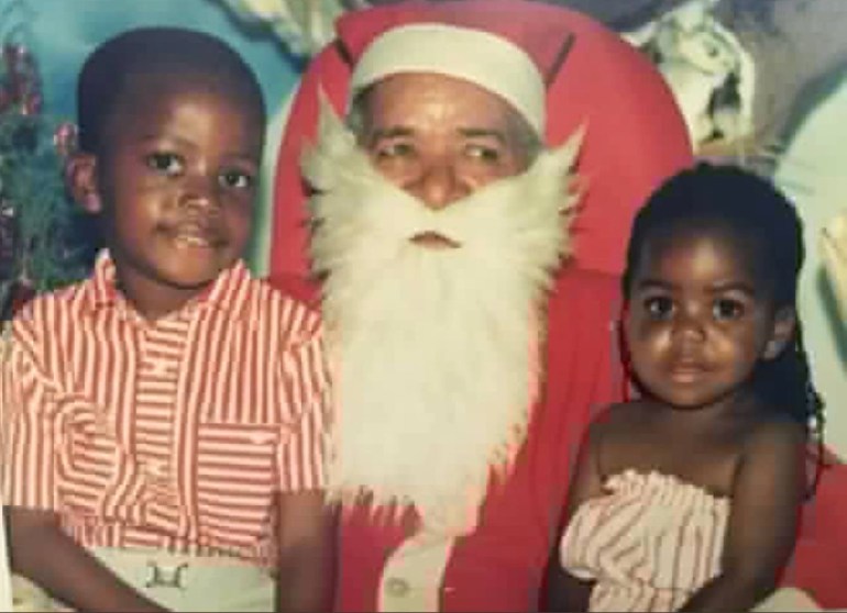 A photo of two boys sitting on Santa Claus's lap.