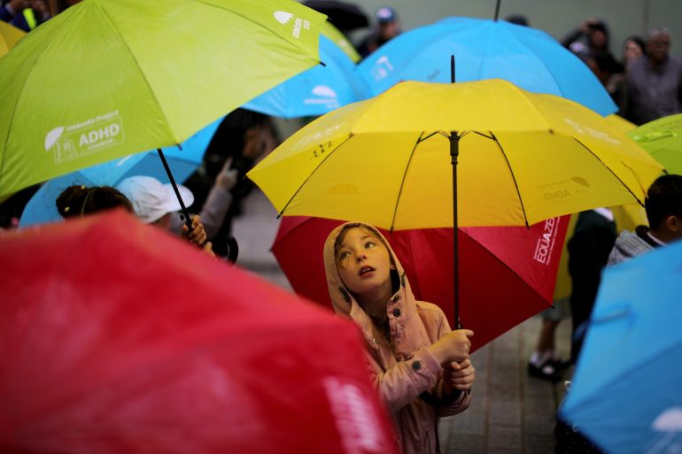 Child dancing under colourful umbrellas