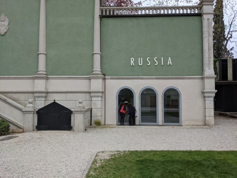 Attendees at the pre-opening of the Venice Biennale peer into the empty Russian pavilion, which closed after the artists and curator pulled out [Ruairi Casey/Al Jazeera]