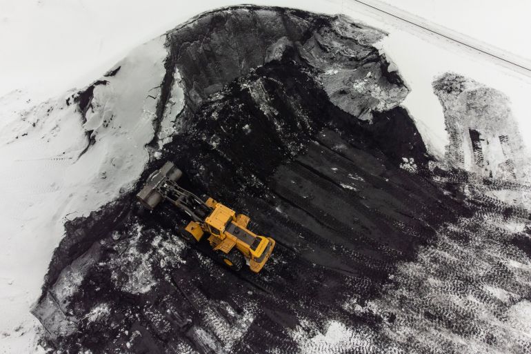 A dump truck moves piles of coking coal in the yard at the Moscow coke and gas plant