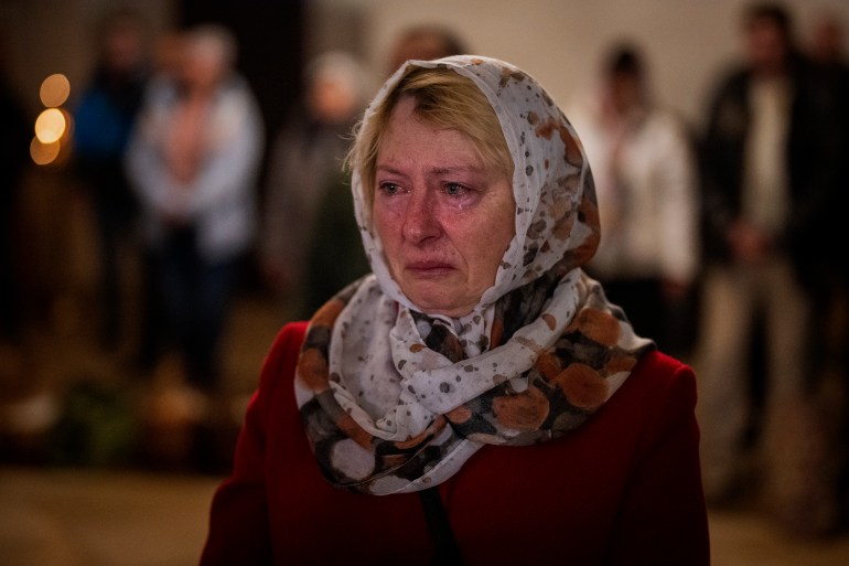 Olga Zhovtobrukh, 55, cries during an Easter religious service at a church in Bucha.