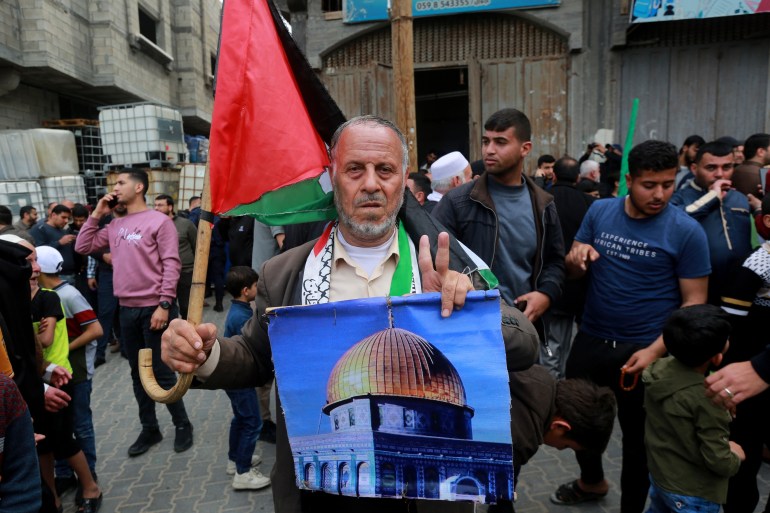 A man held Al-Aqsa mosque painting while taking part in a mass rally 