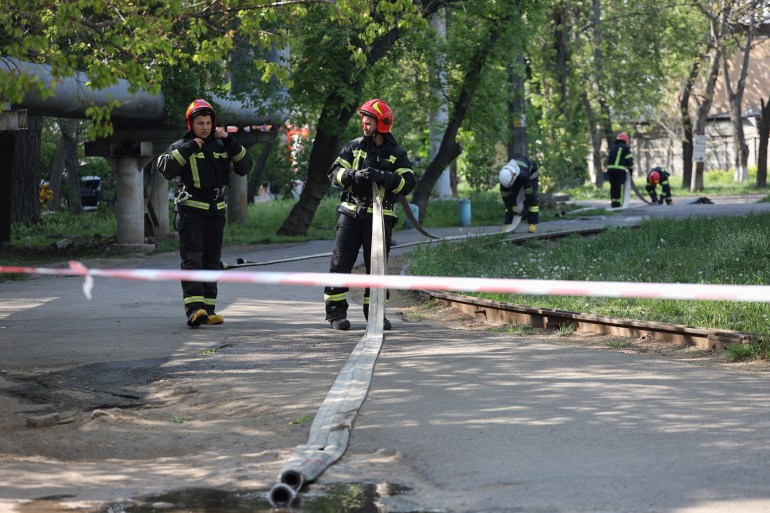 Firefighters work next to a site of a Russian missile attack in southern Ukrainian city of Odesa