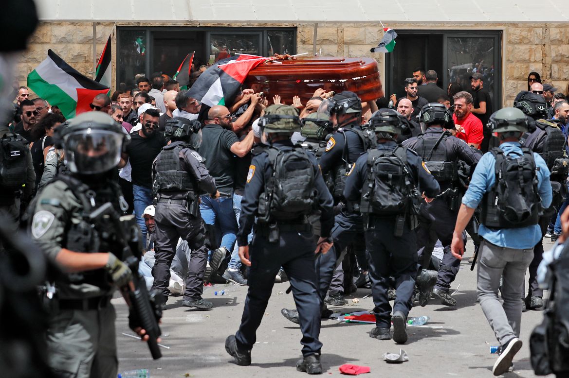 Violence erupts between Israeli security forces and Palestinian mourners carrying the casket of slain Al-Jazeera journalist Shireen Abu Akle out of a hospital, before being transported to a church and then her resting place, in Jerusalem, on May 13, 2022. - Abu Akleh, who was shot dead on May 11, 2022 while covering a raid in the Israeli-occupied West Bank, was among Arab media's most prominent figures and widely hailed for her bravery and professionalism. (Photo by Ahmad GHARABLI / AFP)