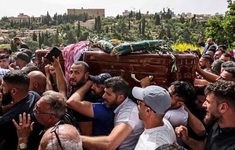 Palestinian mourners carry the coffin