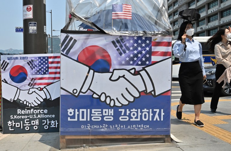 A placard near the US Embassy in Seoul showing the US and Korean flags and two people shaking hands - in support of Biden's visit