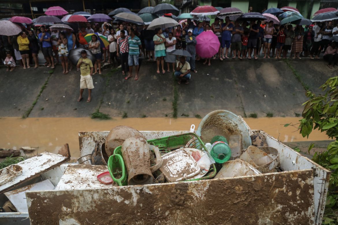 This handout picture release by the Recife City Hall shows residents looking at rescue workers going through the debris near personal belongings recovered from the mud, after a landslide in the community Jardim Monte Verde, Ibura neighbourhood, in Recife, Pernambuco State, Brazil, on May 28, 2022. - Torrential rains that have plagued Brazil's northeastern Pernambuco state since Tuesday have left at least 34 dead, 29 of which occurred over the last 24 hours, according to the latest official update. (Photo by Diego NIGRO / RECIFE CITY HALL / AFP) / RESTRICTED TO EDITORIAL USE - MANDATORY CREDIT "AFP PHOTO / RACIFE CITY HALL / DIEGO NIGRO" - NO MARKETING - NO ADVERTISING CAMPAIGNS - DISTRIBUTED AS A SERVICE TO CLIENTS