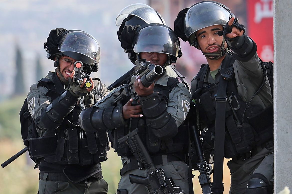 Israeli border guards take aim during clashes with Palestinian protesters.