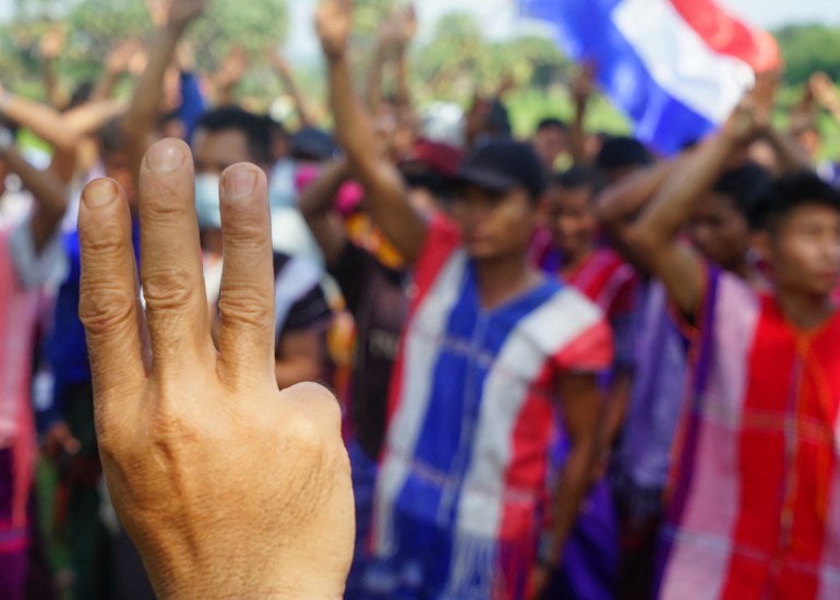 protesters in ethnic costumes raising the three finger salute during a demonstration against the military coup in the area under the control of Karen National Union (KNU)