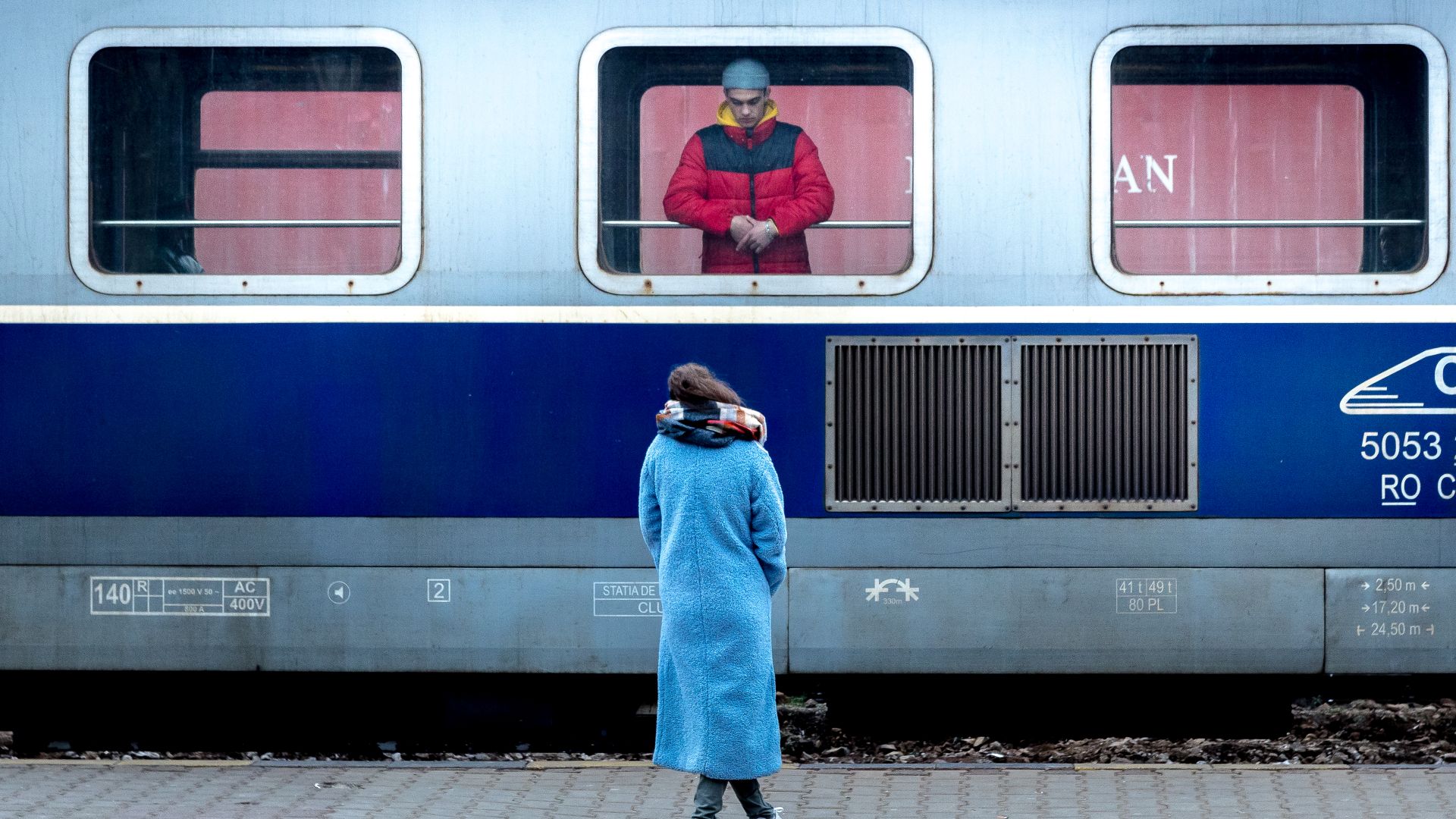 Two people say goodbye at a train station