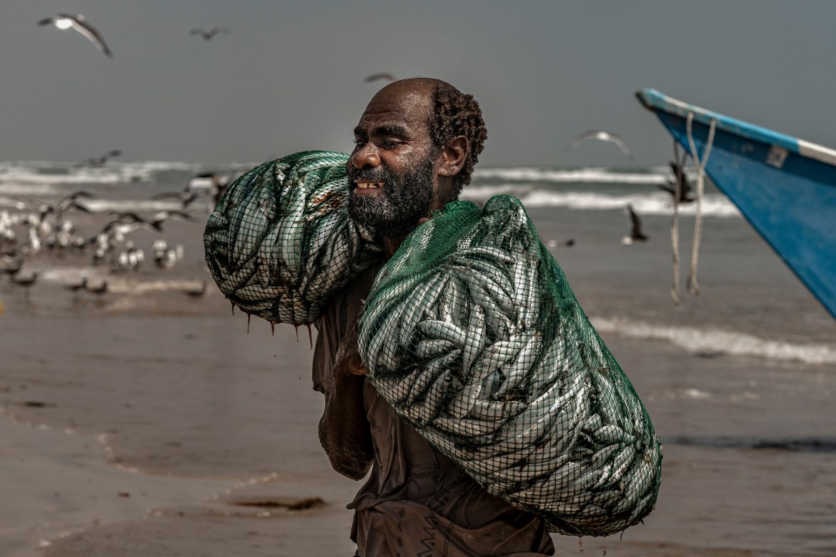 A man returns to shore with his catch for the day at Sayhut fishing village, between Itab and Sharkhut.