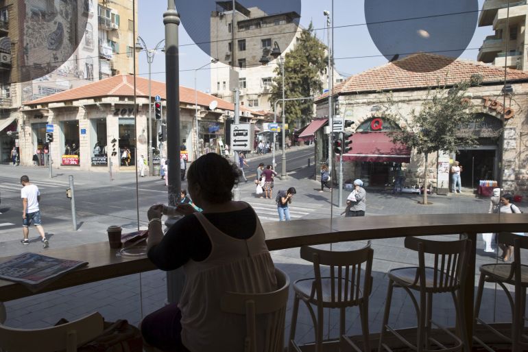 A woman sits at a cafe in the centre of Jerusalem October 19, 2015. A surge in Palestinian attacks in Israel is raising concerns that the weakening economy could eventually be pushed into recession. REUTERS/Ronen Zvulun