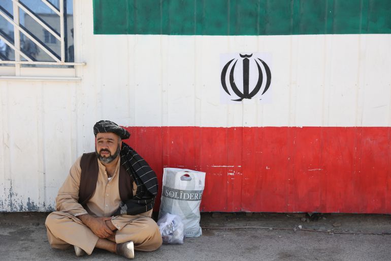 An Afghan man sits at the Dowqarun border crossing between Iran and Afghanistan, Razavi Khorasan Province, Iran