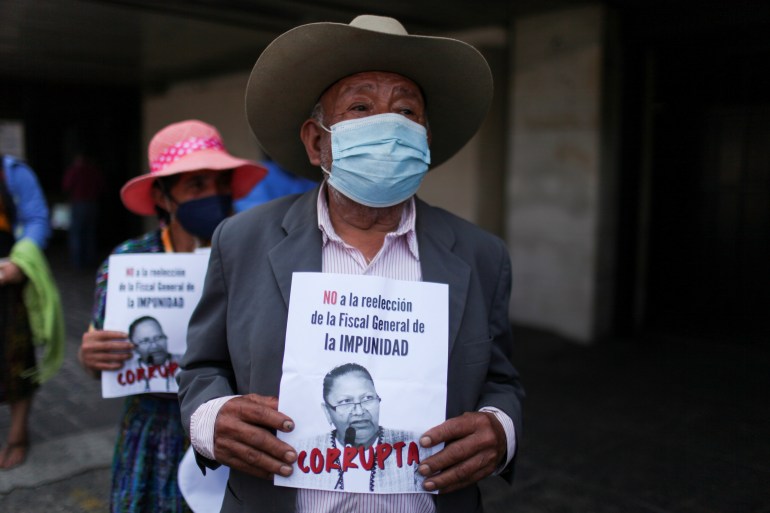Demonstrators hold signs denouncing Guatemala's attorney general
