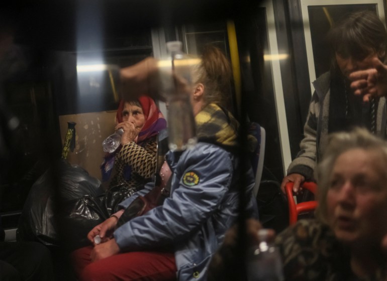 Ukrainian refugees from the Azovstal steel plant in Mariupol are seen in a bus as they arrive in Zaporizhzhia