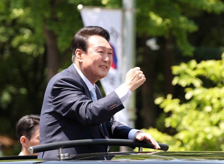 South Korea's new President Yoon Suk-yeol waves to his supporters while leaving after attending his inauguration ceremony.