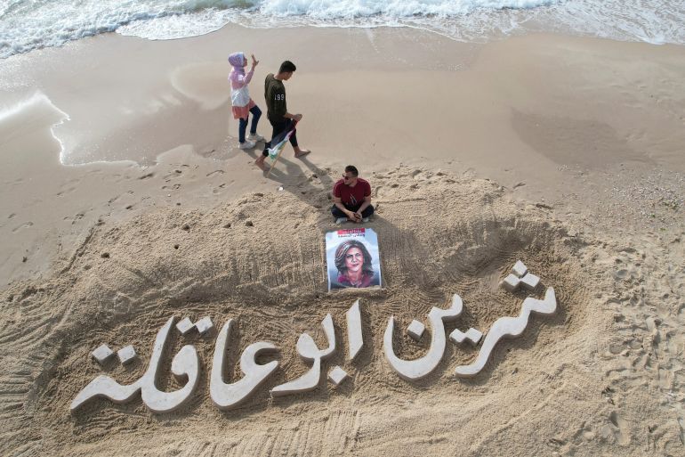 A sand sculpture reads 'Shireen Abu Akleh'