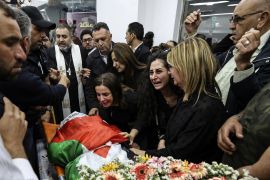 People react as the body of Al Jazeera reporter Shireen Abu Akleh.