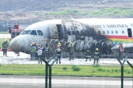 Rescue workers around an Airbus A319 plane of Tibet Airlines caught fire after an aborted takeoff, at Chongqing Jiangbei International Airport