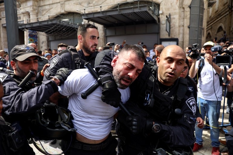 Members of the Israeli security forces detain a man during the funeral of Al Jazeera reporter Shireen Abu Akleh.