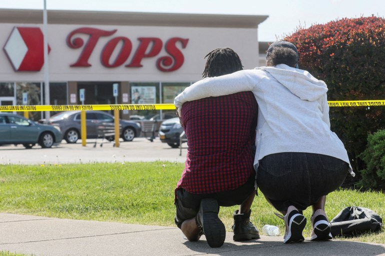 Mourners react while attending a vigil for victims of the shooting at a TOPS supermarket in Buffalo, New York.