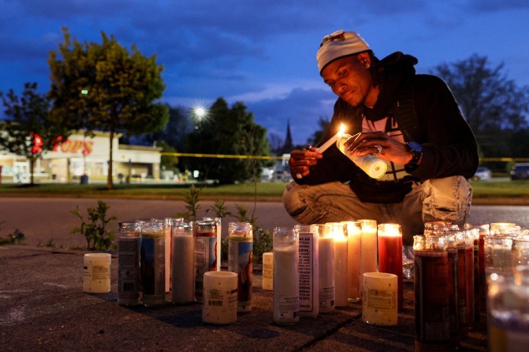 A man lights a candle outside the site of a deadly attack in Buffalo, New York