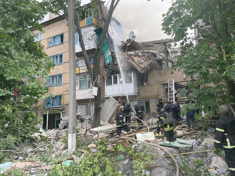Fire and rescue crews work at the site of a damaged five-storey residential building after it was struck, by what was reported to be rocket fire, during Russia's invasion of Ukraine, in Bakhmut,