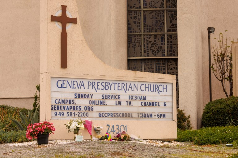Flowers left against the sign board for the Geneva Presyterian Church