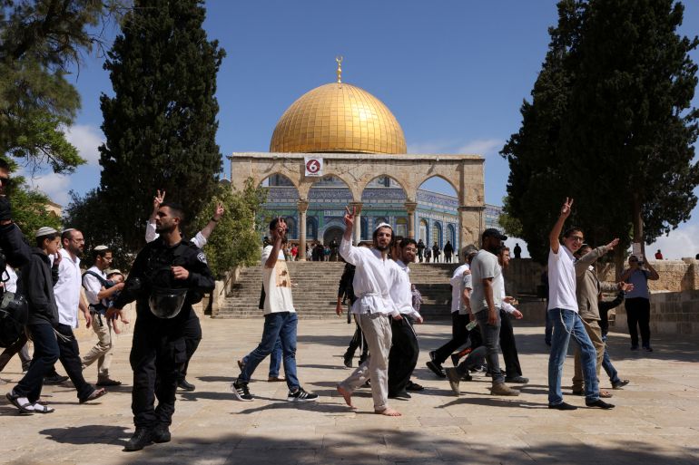 FILE PHOTO: Jewish visitors gesture as Israeli security forces secure the area at the compound that houses Al-Aqsa Mosque, known to Muslims as Noble Sanctuary and to Jews as Temple Mount, in Jerusalem's Old City