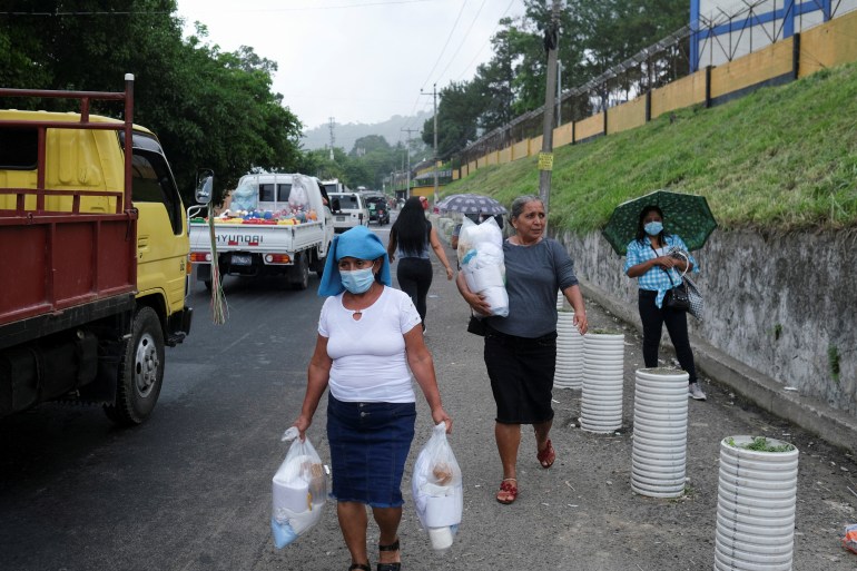 Women carry supply packages for their relatives detained in El Salvador's anti-gang crackdown