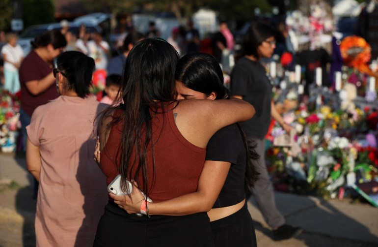 Women embrace at a memorial in Uvalde, Texas