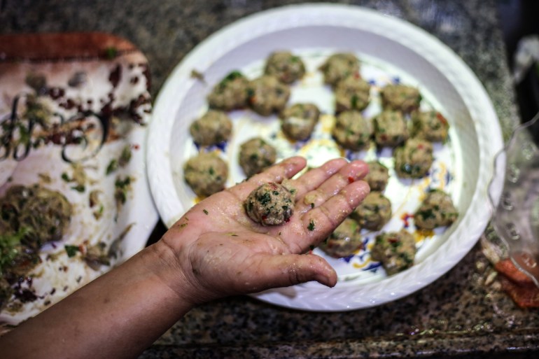 A view of Khadr's mother's hand holding a small fish ball she has just shaped