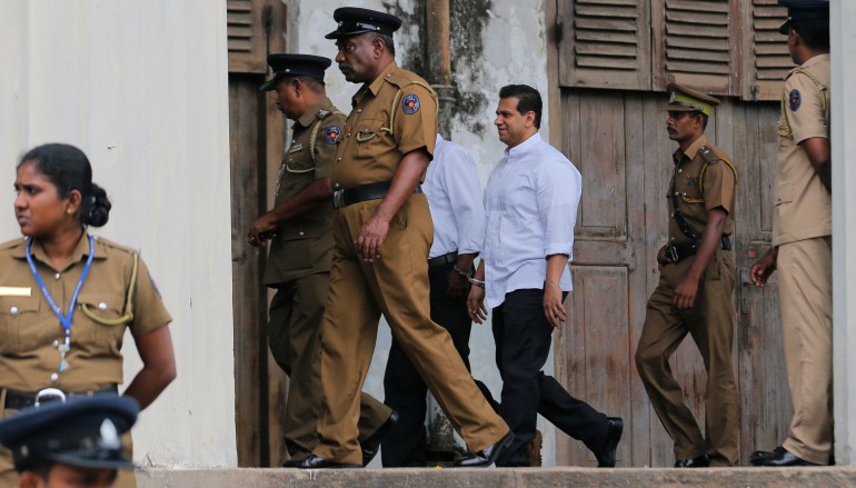 Sri Lankan police and prison officers escort former lawmaker Duminda Silva in Colombo.