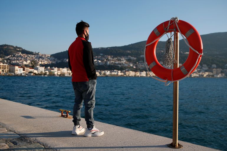 An Afghan father stands at the port of Vathy on the eastern Aegean island of Samos