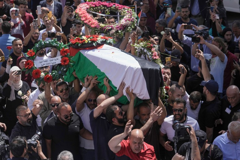 Family, friends and colleagues of slain Al Jazeera journalist Shireen Abu Akleh carry her coffin to a hospital