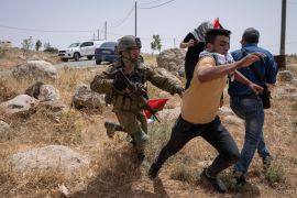 An Israeli soldier chases a protester