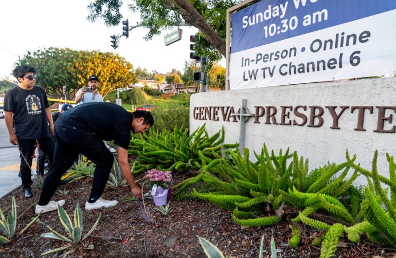Hector Gomez, left, and Jordi Poblete, worship leaders at the Mariners Church Irvine, leave flowers outside the Geneva Presbyterian Church in Laguna Woods, California.