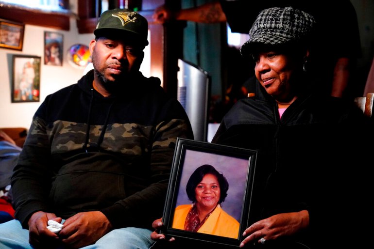Wayne Jones, left, looks on as his aunt JoAnn Daniels, holds a photograph of his mother Celestine Chaney, who was killed in Saturday's shooting at a supermarket in Buffalo, N.Y.