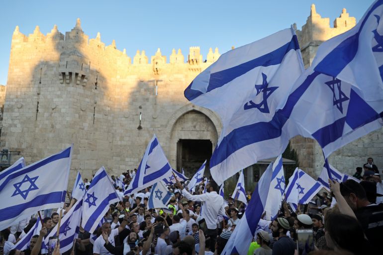 Jewish ultra-nationalists wave Israeli flags during the "Flags March," next to Damascus gate, outside Jerusalem's Old City, June 15, 2021.