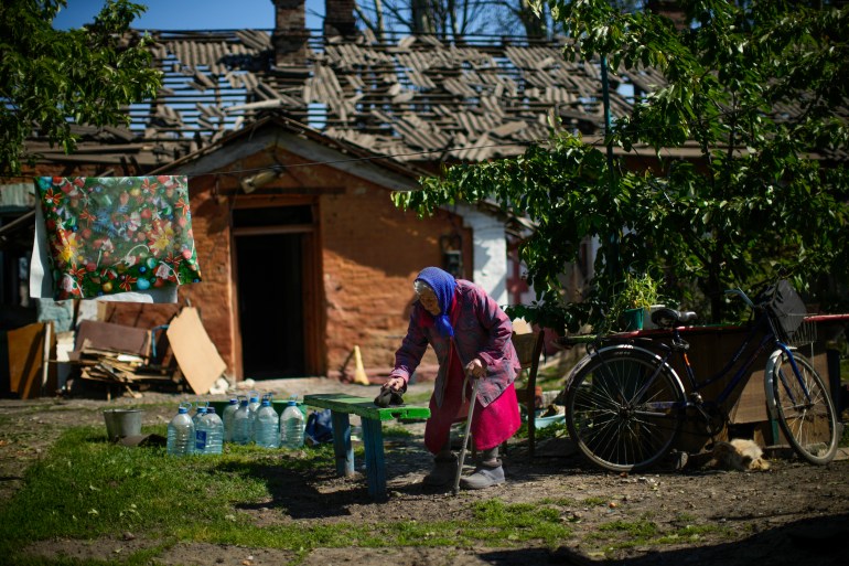 Local resident Valeria removes dust from a bench outside her heavily damaged house after a Russian strike in Pokrovsk, eastern Ukraine, Wednesday, May 25, 2022