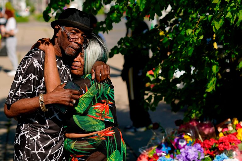 People embrace outside the scene of the racist mass shooting in Buffalo, New York.