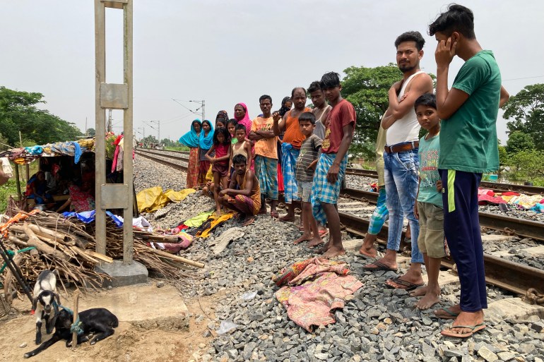 locals stand next to a rail track in Nagaon. Hundreds of people moved next to these tracks to escape floodwaters.
