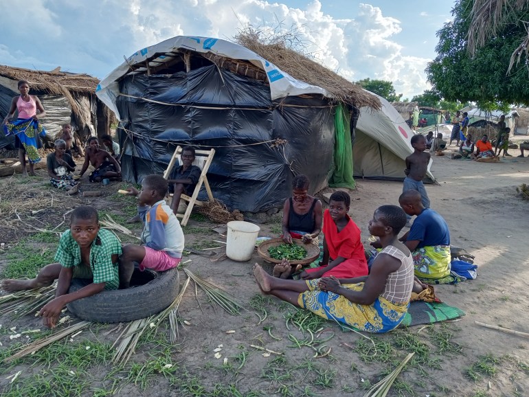 Villagers from Chikawa district in Malawi sit by makeshift houses built after the latest floods