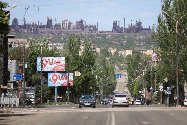 A view of a street in Mariupol, captured by Russian forces, with the Azovstal steel plant in the background.