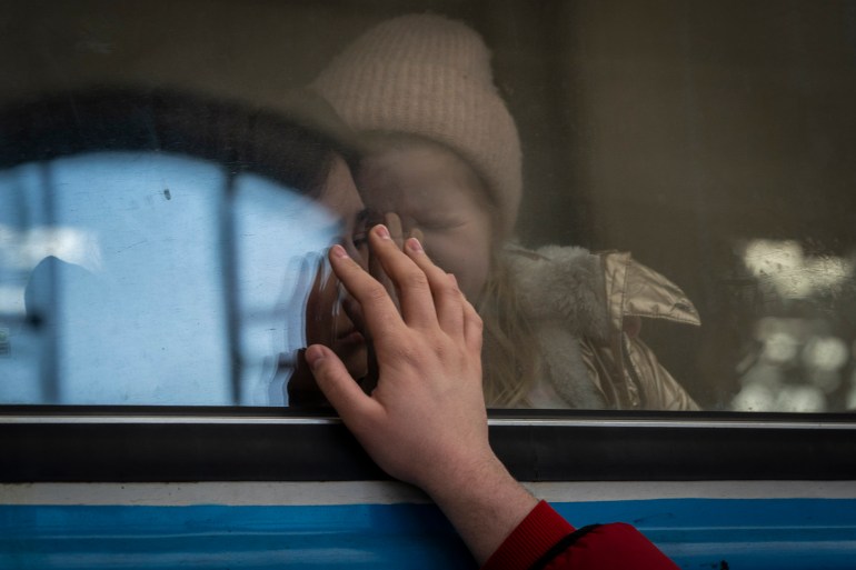 Displaced Ukrainians on a Poland-bound train bid farewell in Lviv, western Ukraine, Tuesday, March 22, 2022