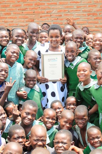 Temwani Chilenga with the children after presented with a Point of Light Award